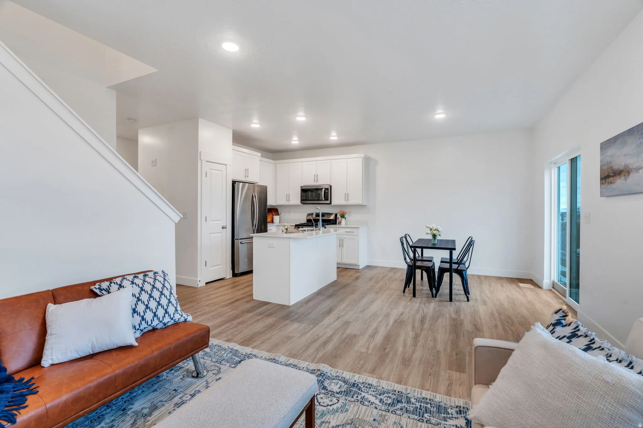 Living room with light wood finished floors and recessed lighting