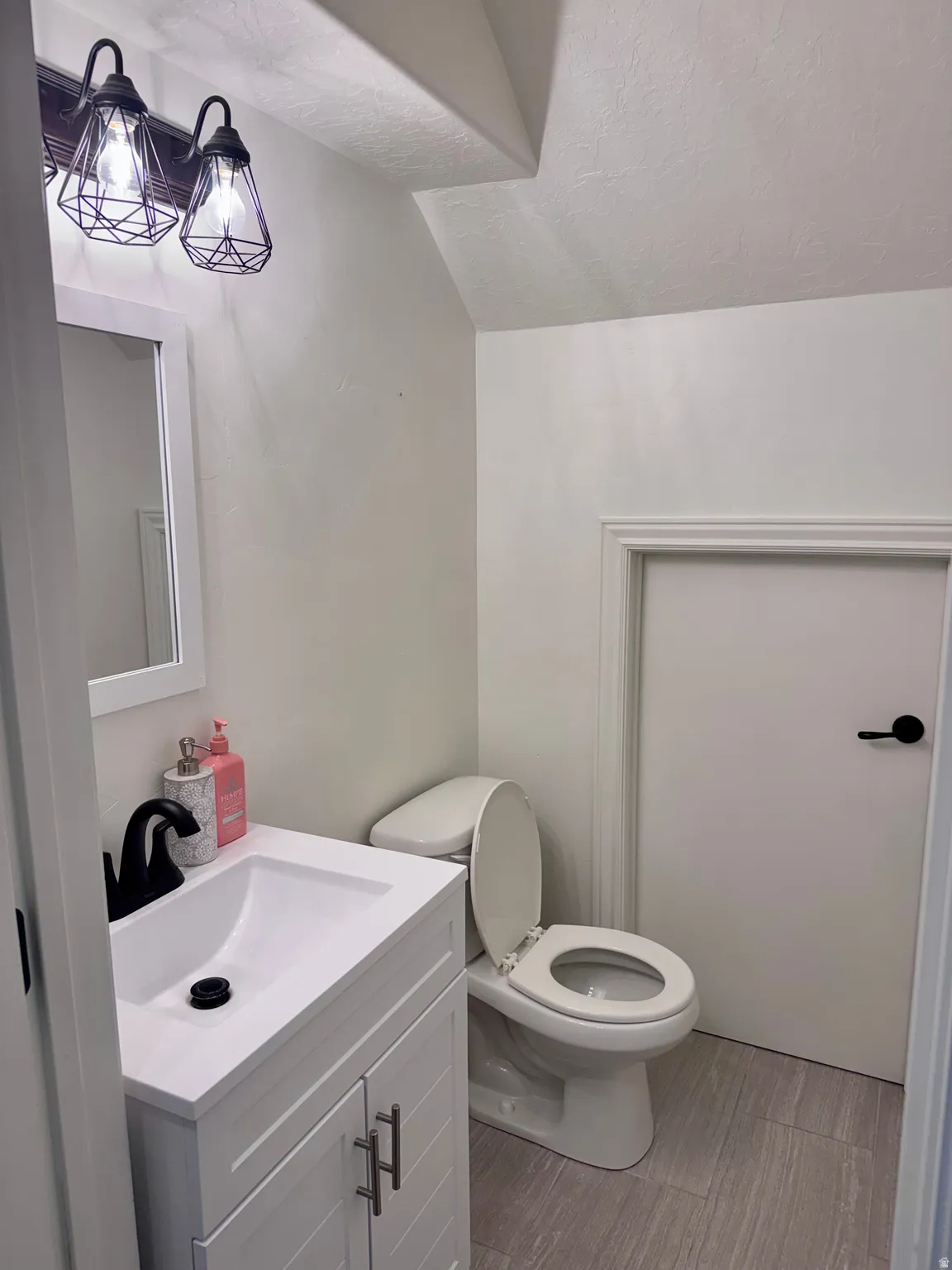 Half bathroom with vanity and toilet