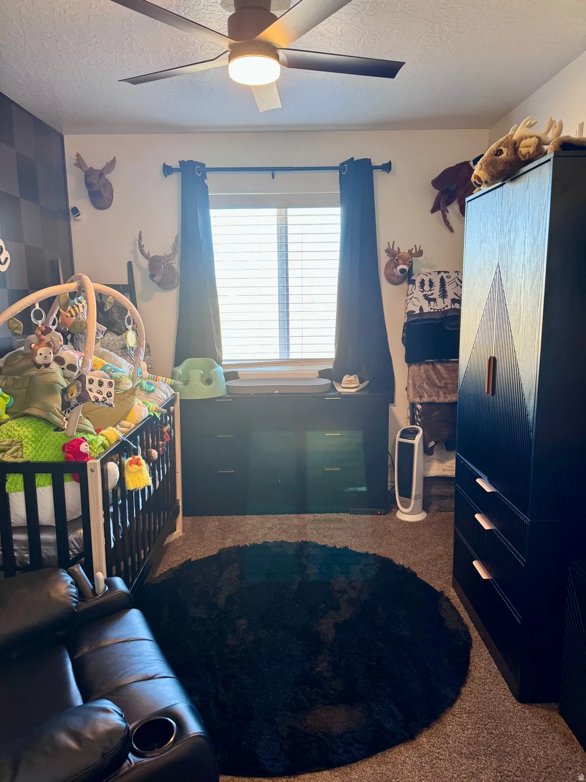 Carpeted bedroom with a textured ceiling and ceiling fan