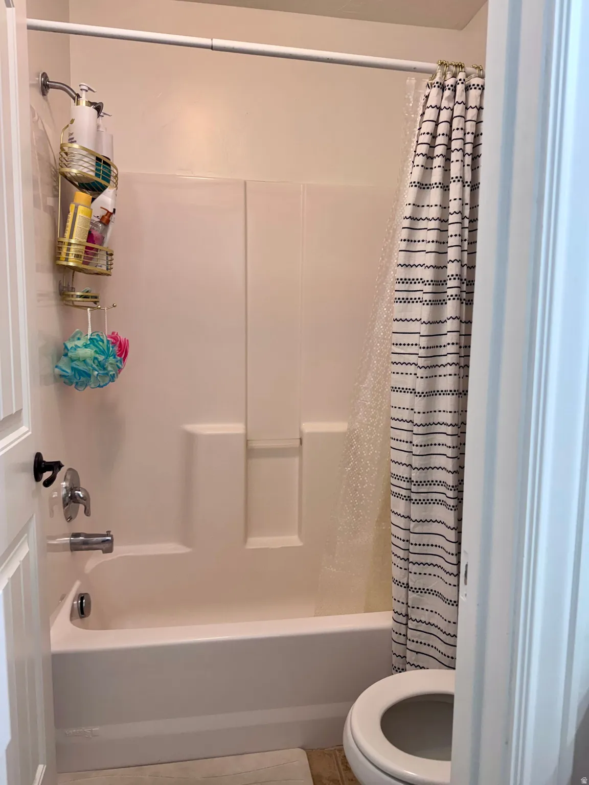 Full bathroom with shower / bathtub combination with curtain and toilet