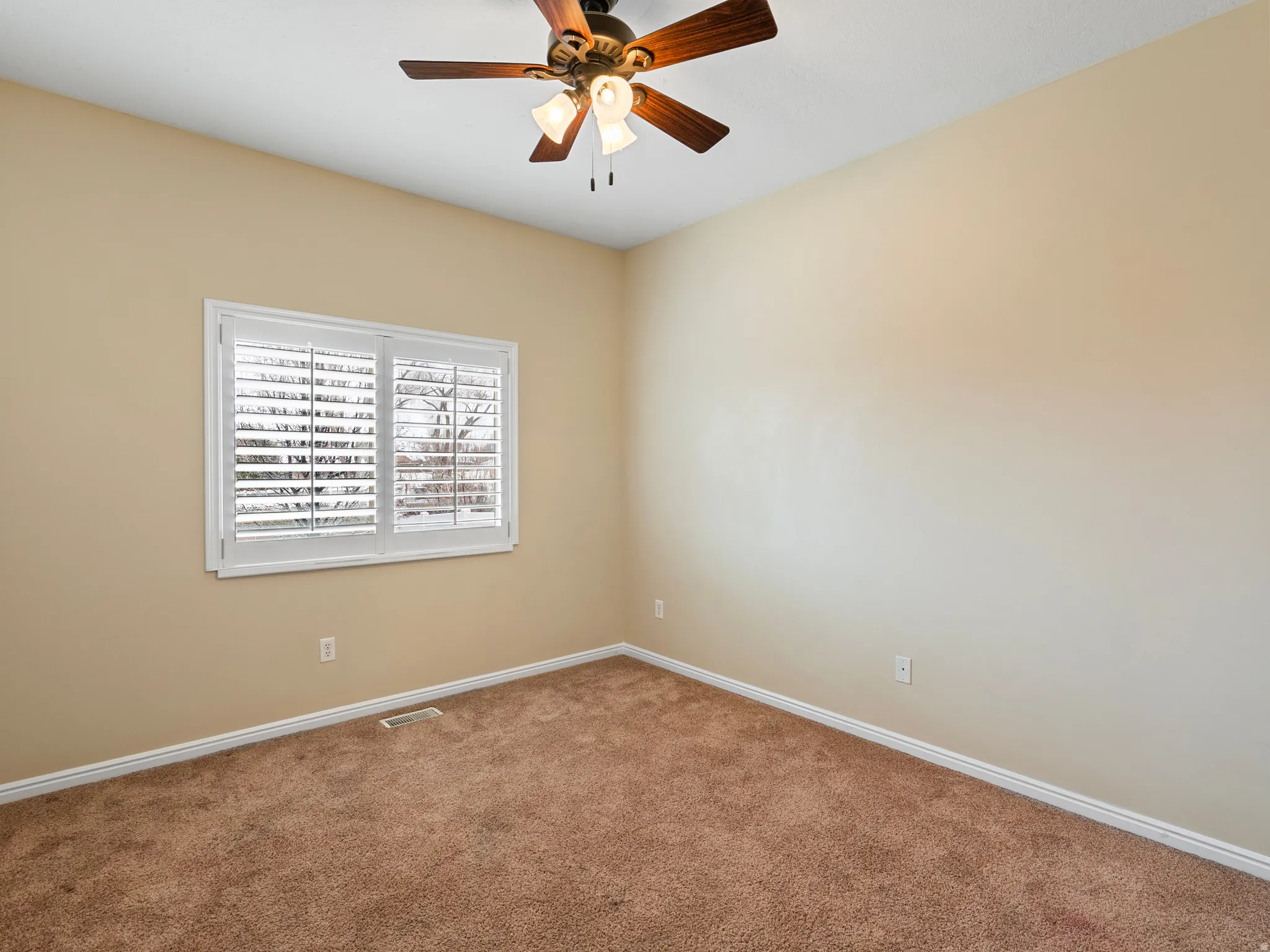 Empty room with carpet flooring and ceiling fan