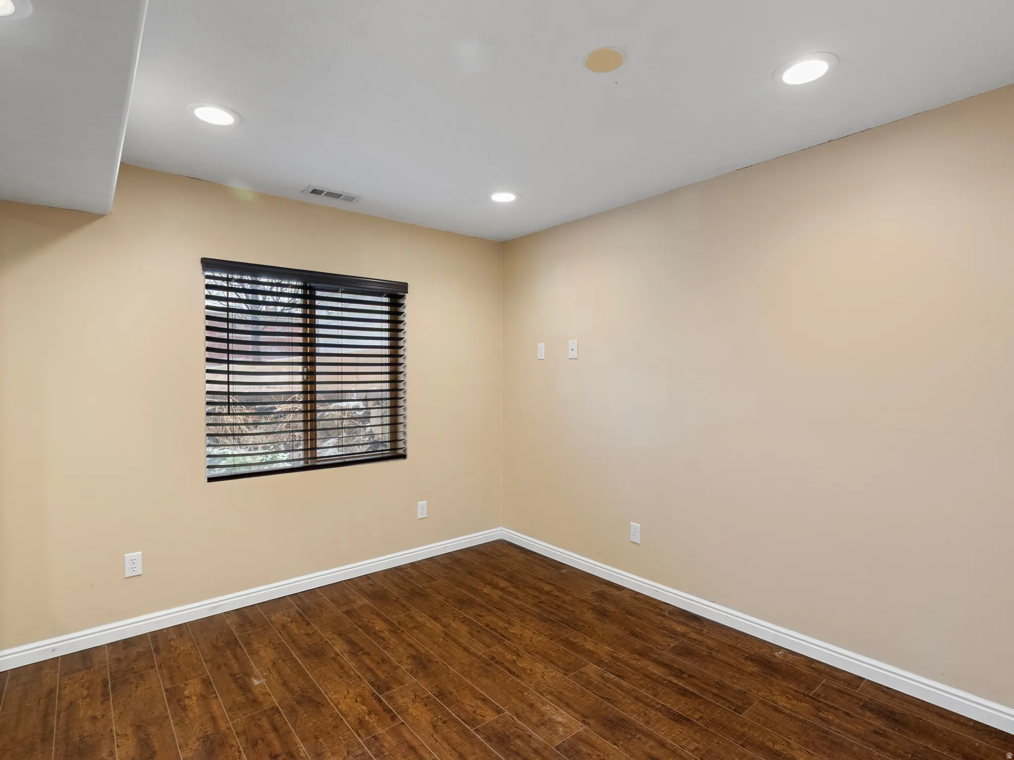 Spare room featuring dark wood-style flooring and recessed lighting