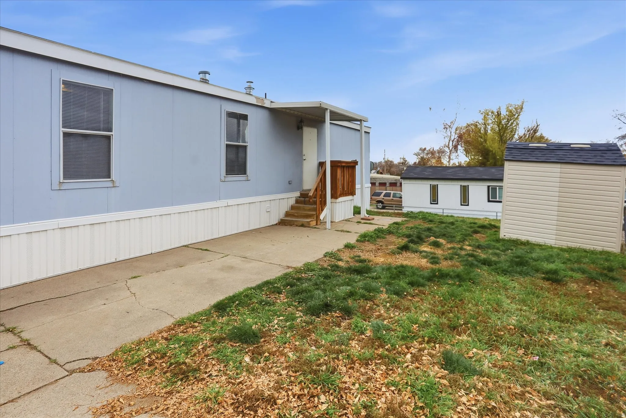 View of front of property with a front lawn and a storage shed