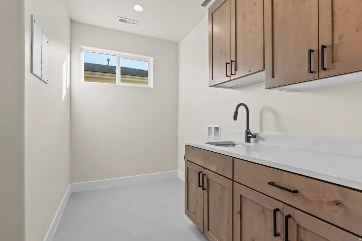 Laundry area with cabinet space, hookup for a washing machine, and recessed lighting