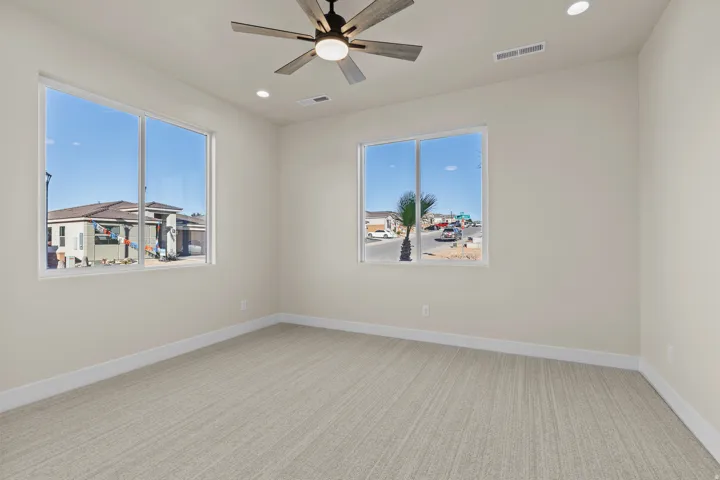 Unfurnished room featuring light colored carpet, ceiling fan, recessed lighting, and plenty of natural light