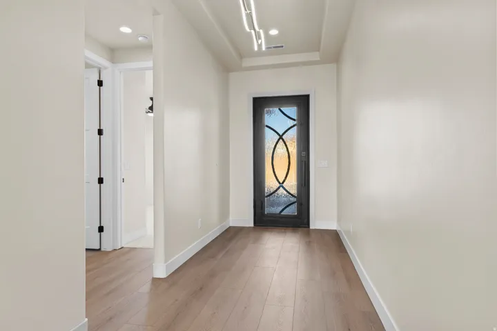 Foyer with light wood-type flooring and baseboards