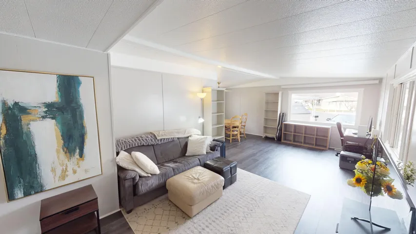 Living area featuring beamed ceiling and wood finished floors