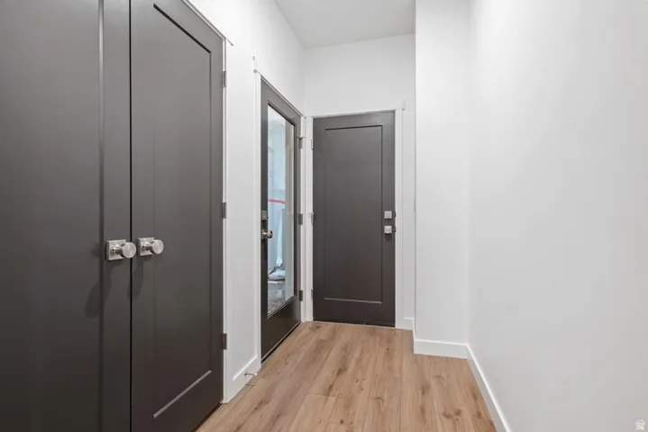 Doorway to outside featuring baseboards and wood finished floors