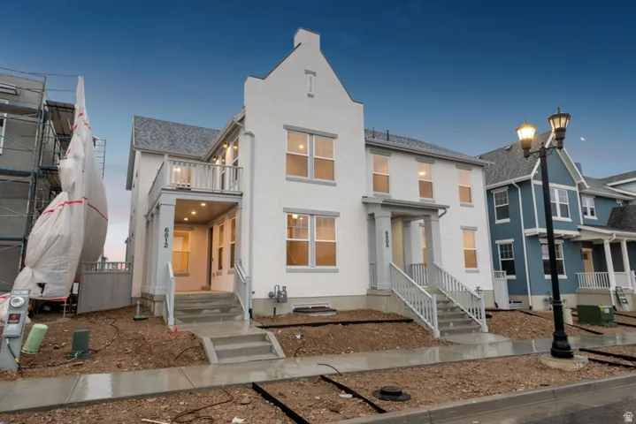 View of front of home featuring stucco siding and a balcony