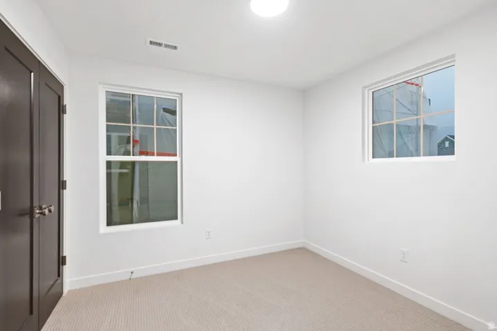 Spare room with light carpet and baseboards