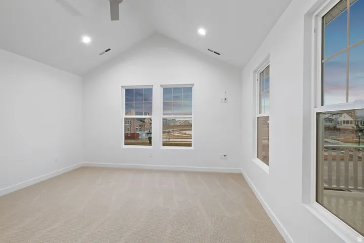 Empty room with light carpet and a ceiling fan