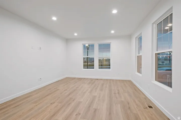 Empty room featuring light wood-style flooring and recessed lighting