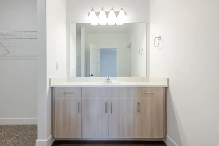 Vanity with a light-toned wood-finish cabinet, integrated sink, and light-colored countertop