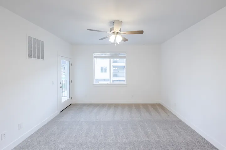 Light-toned carpeting and neutral wall tones, with a ceiling fan overhead