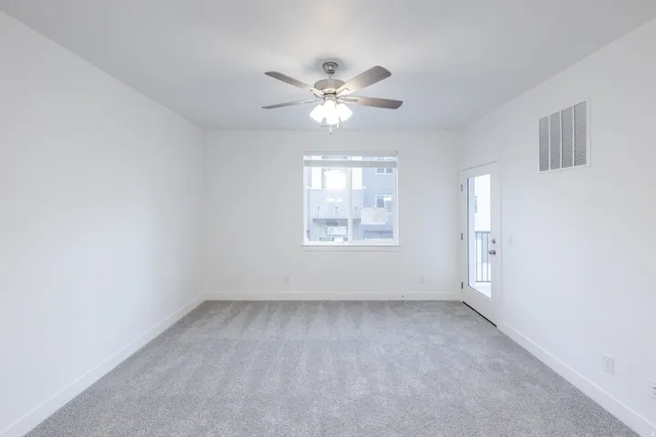 Recessed lighting, ceiling fan with integrated lighting, expansive window, glass-paneled door, and plush carpeting