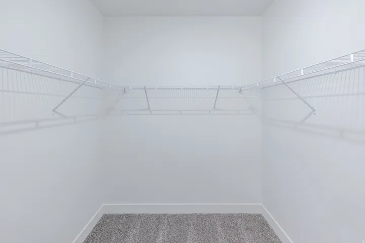 Wall-to-wall wire shelving, L-shaped shelving configuration, and gray carpeting