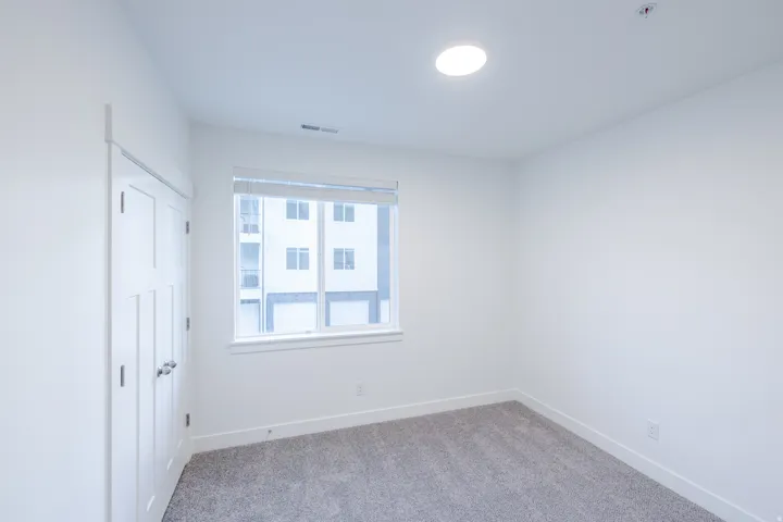 Recessed lighting, window with blinds, dual closet doors, and gray carpeting
