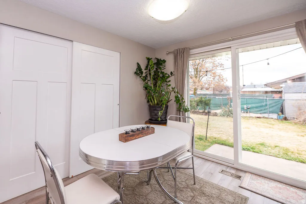 Dining space featuring light wood-style flooring and a textured ceiling