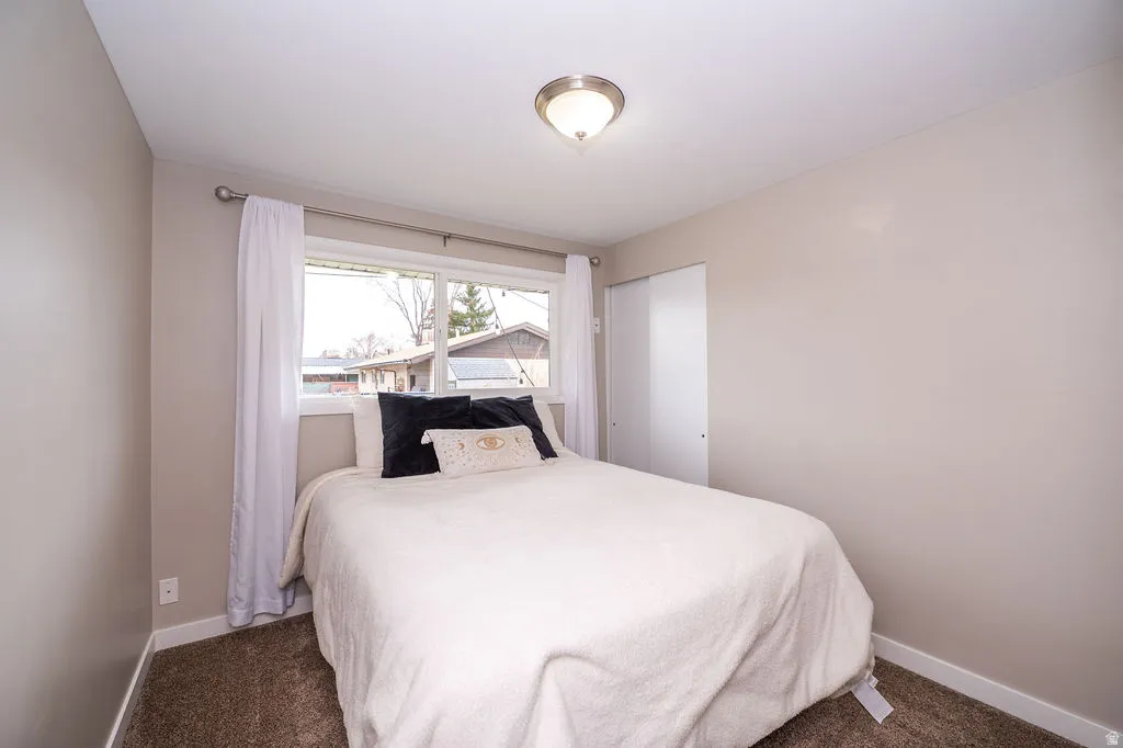 Bedroom with a closet and dark carpet