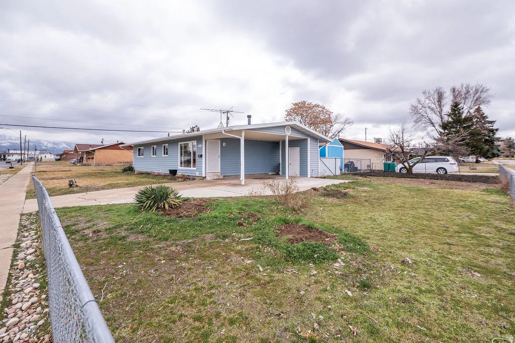 View of front facade featuring a carport, a patio area, and concrete driveway