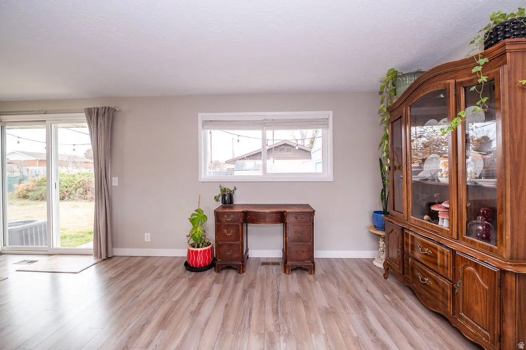 Office space featuring light wood-style floors and a textured ceiling