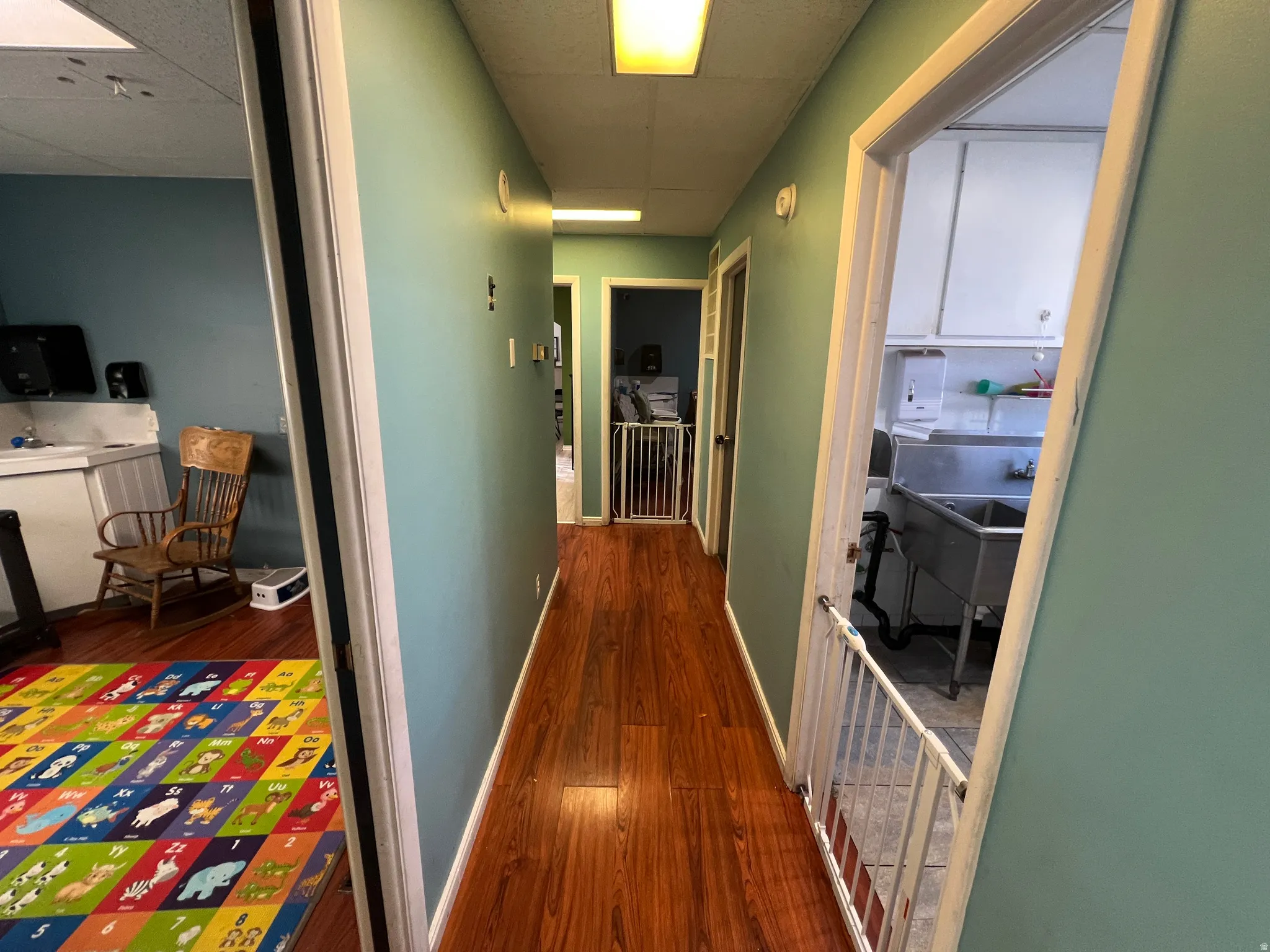 Hallway featuring wood finished floors and a paneled ceiling