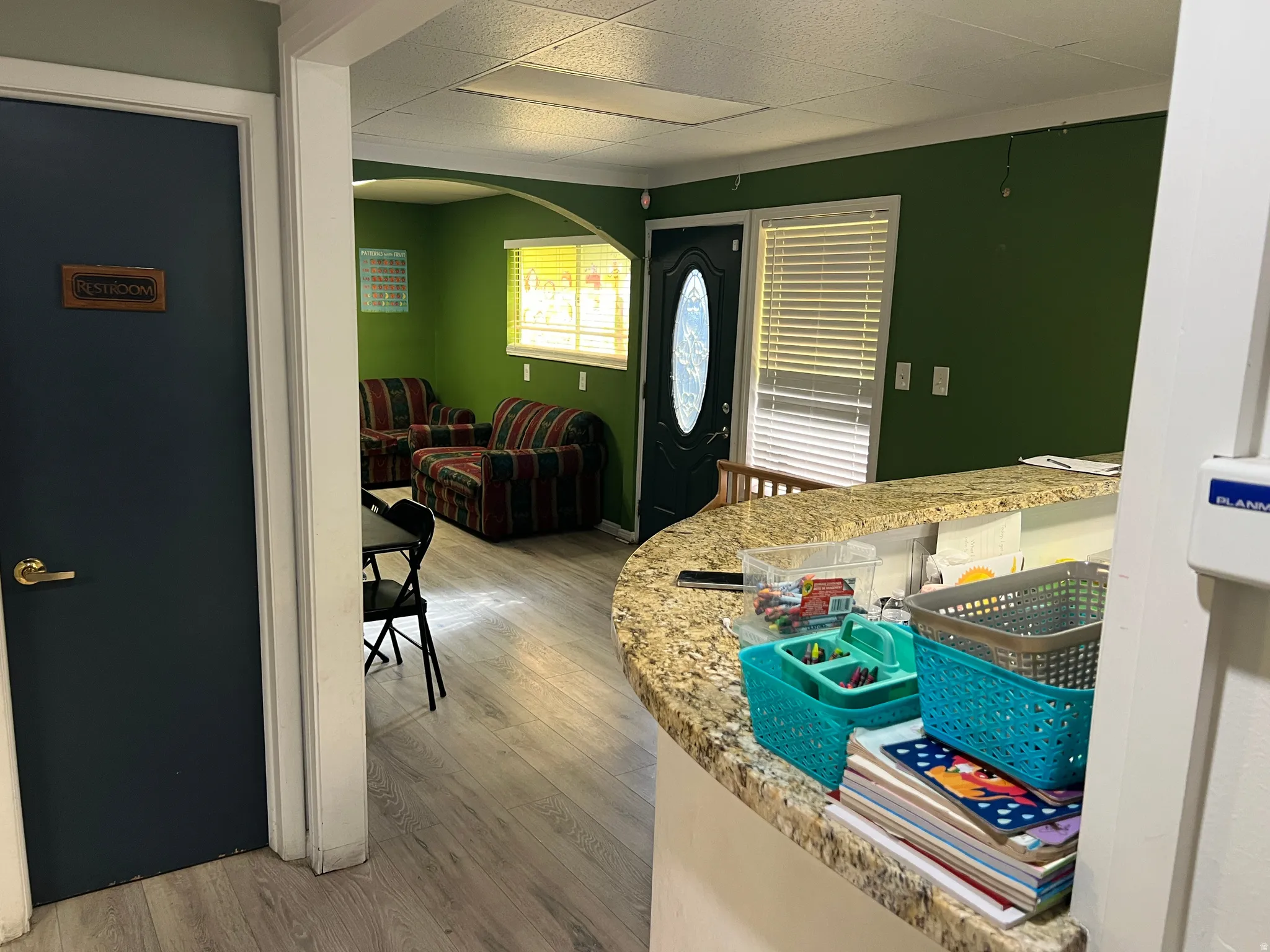 Kitchen featuring arched walkways, light wood-type flooring, and light stone counters