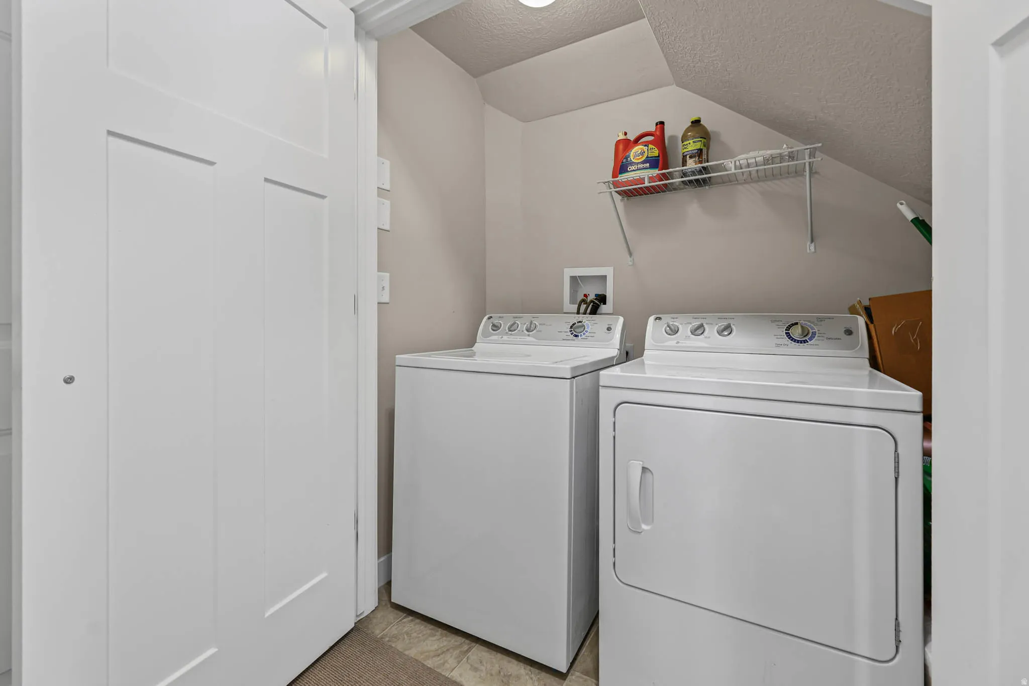 Laundry area with a textured ceiling and washer and dryer