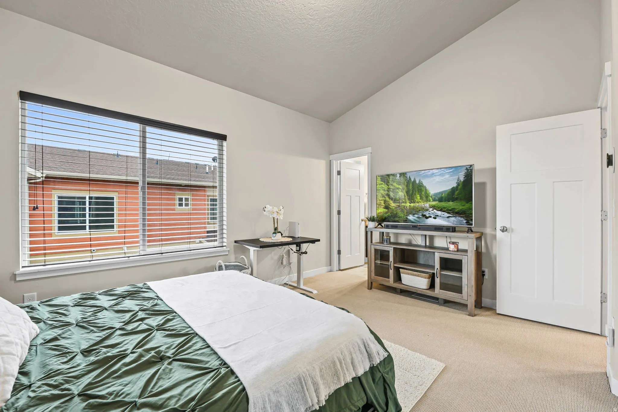Bedroom with light colored carpet and baseboards