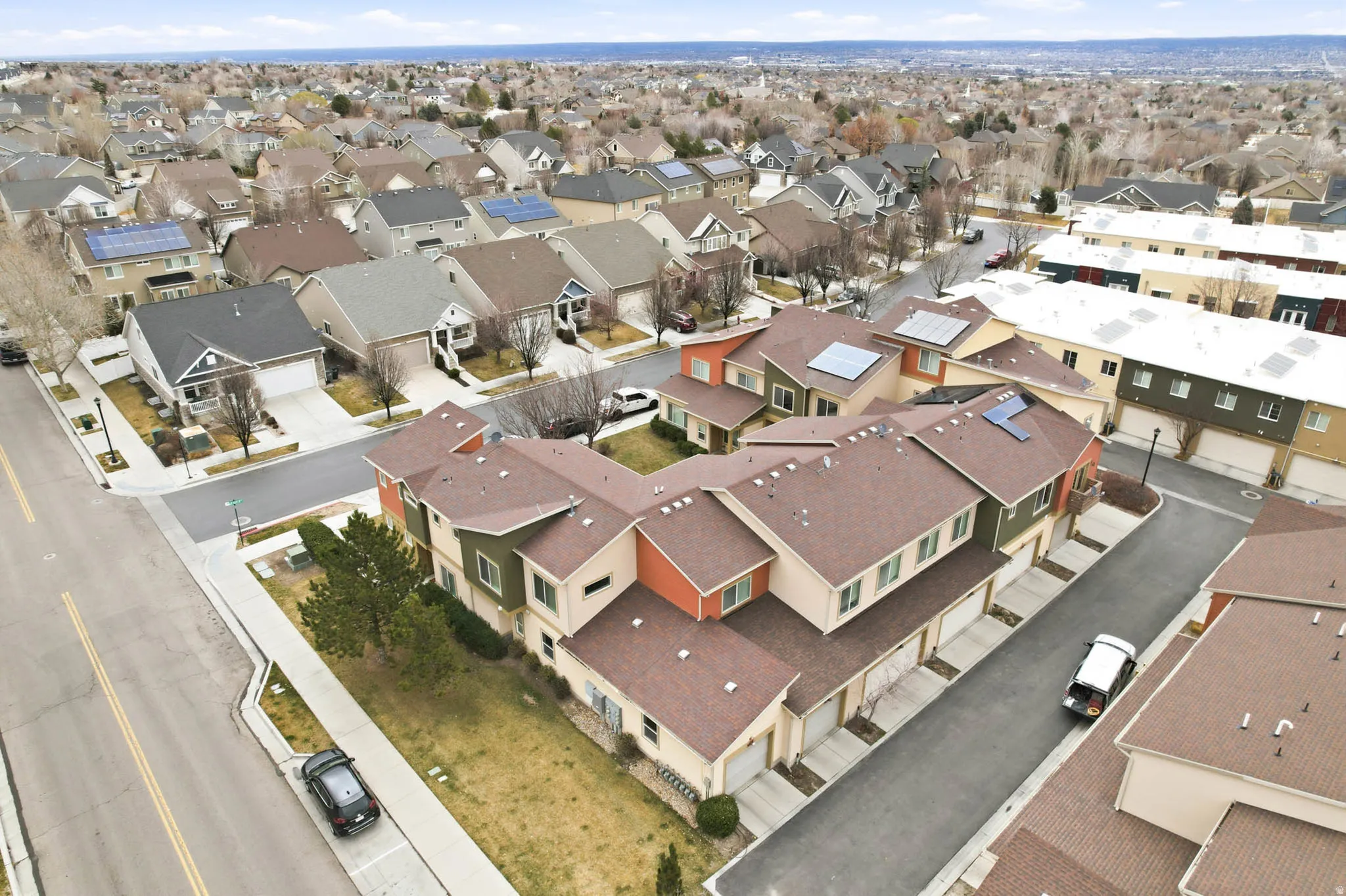 Aerial view of property and surrounding area with nearby suburban area