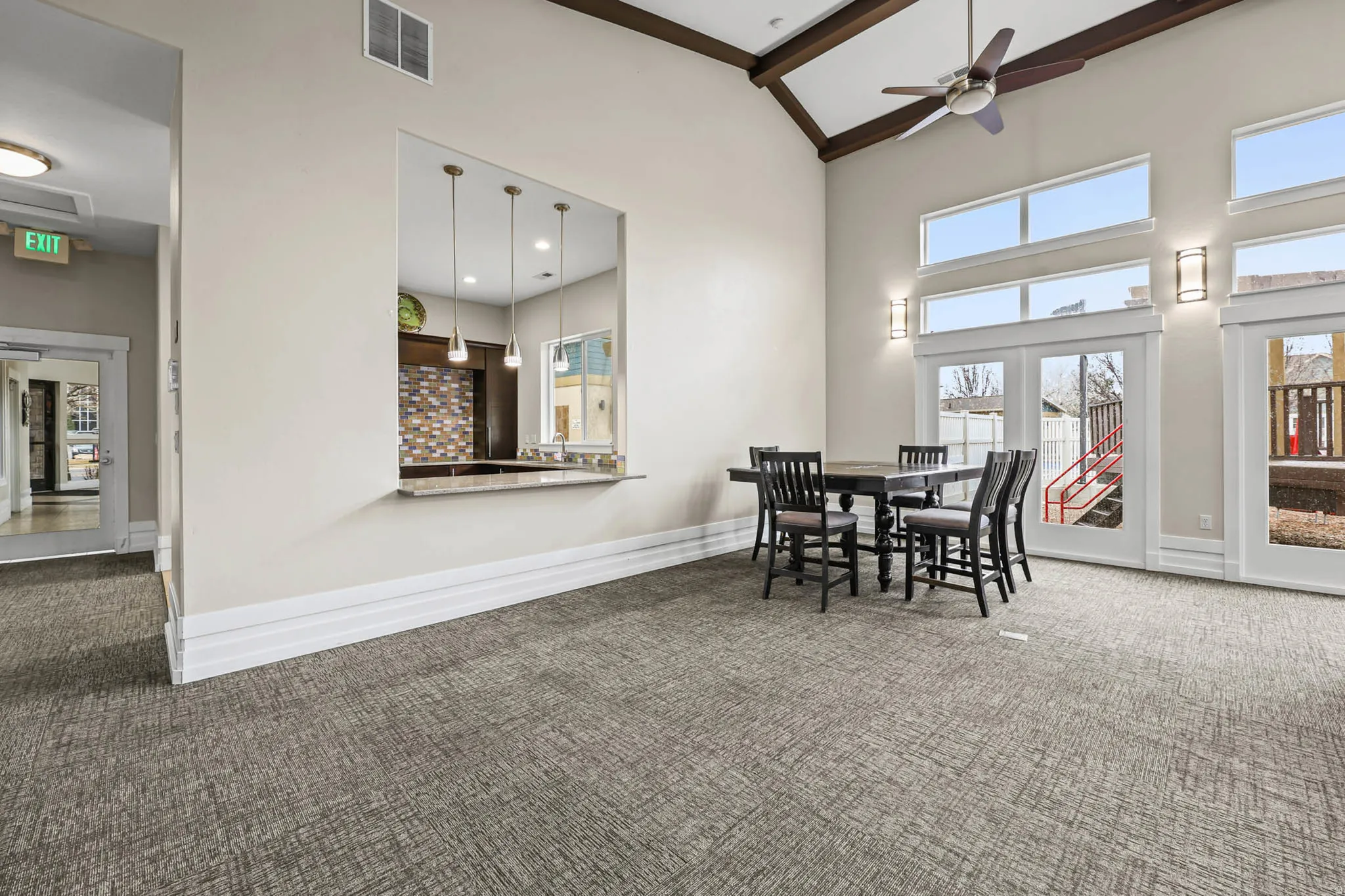 Dining area featuring carpet floors, a ceiling fan, and vaulted ceiling