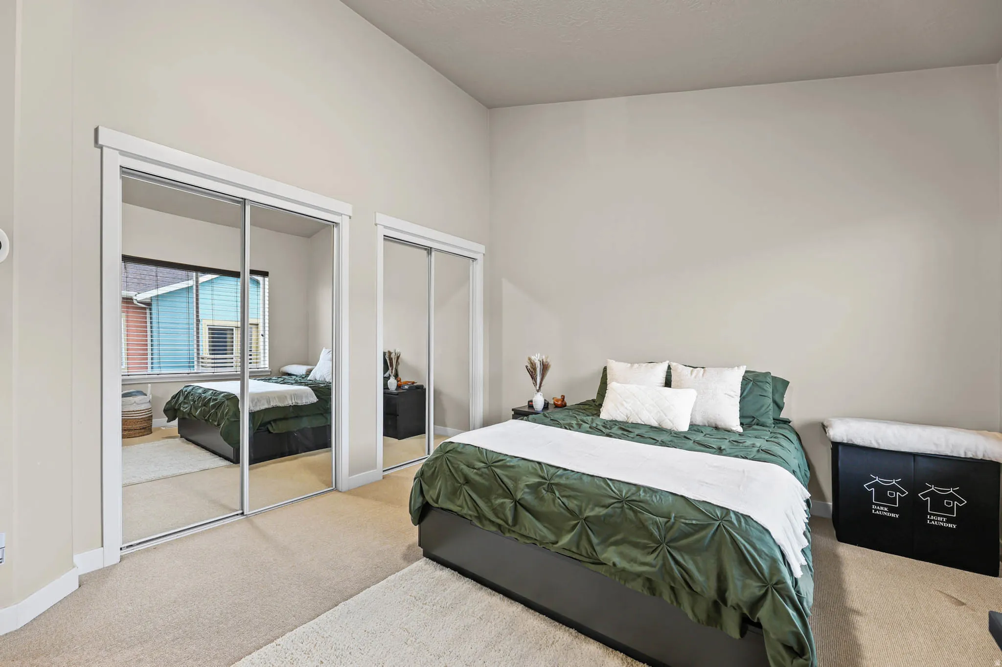 Carpeted bedroom featuring multiple closets and baseboards