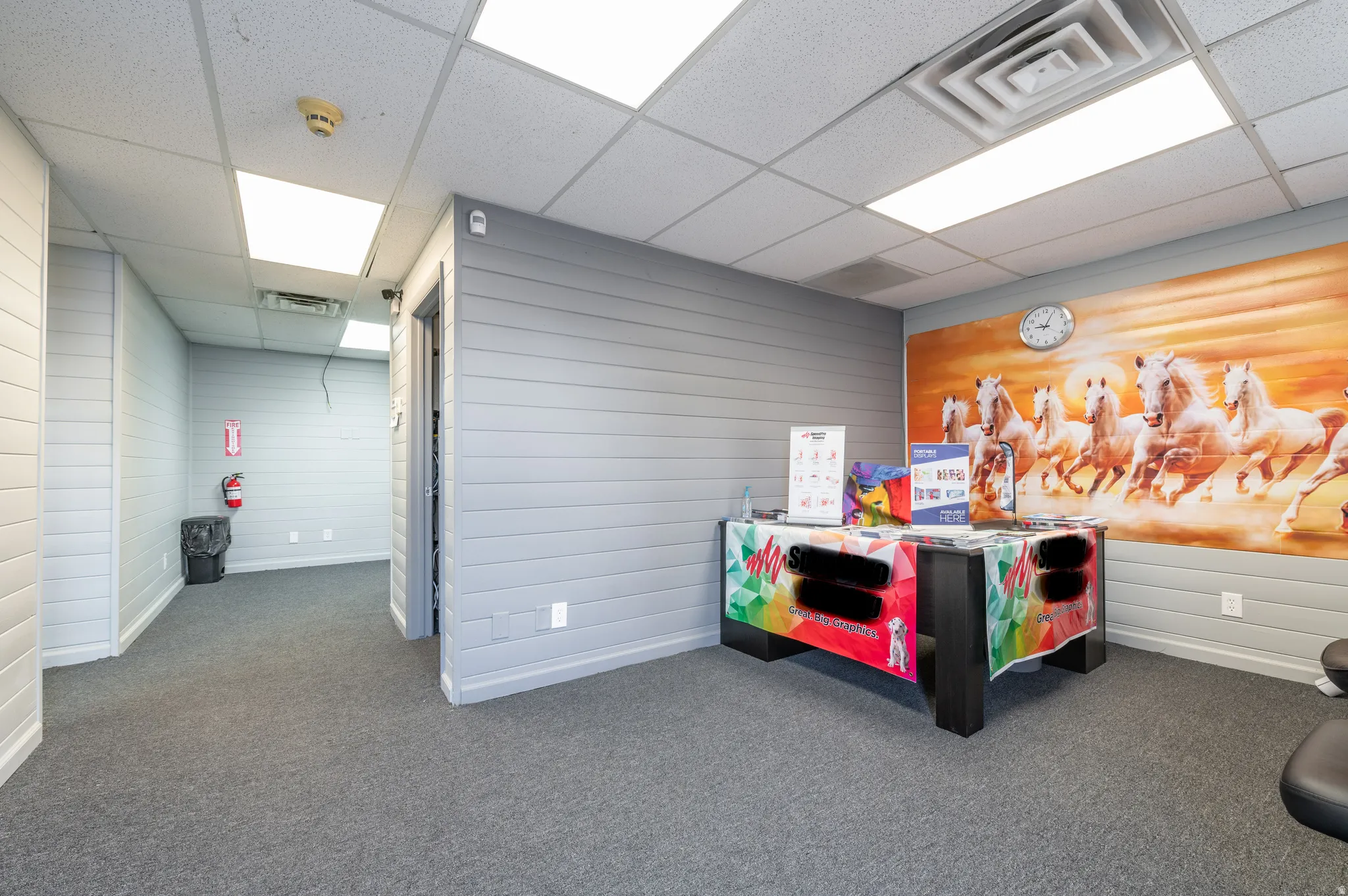Bedroom with a paneled ceiling, dark colored carpet, and wood walls