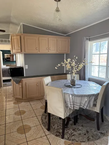 Dining space featuring light tile patterned floors and crown molding