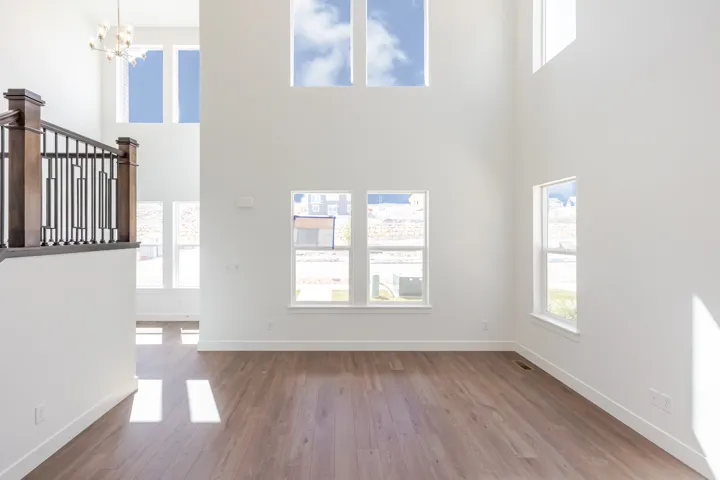 Two-story great room featuring high ceilings and multiple windows