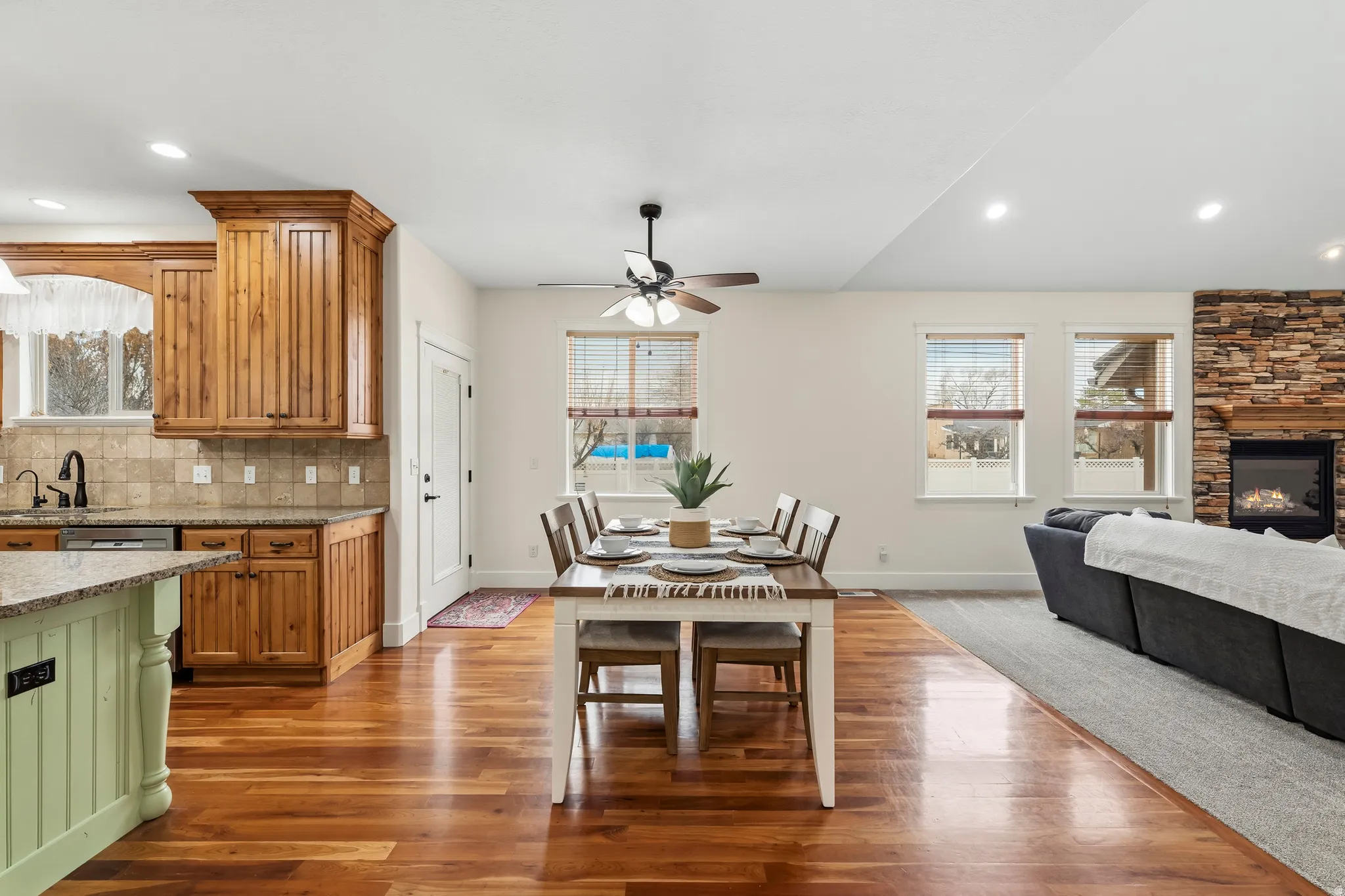 Dining area with healthy amount of natural light, a fireplace, recessed lighting, and dark wood-style flooring