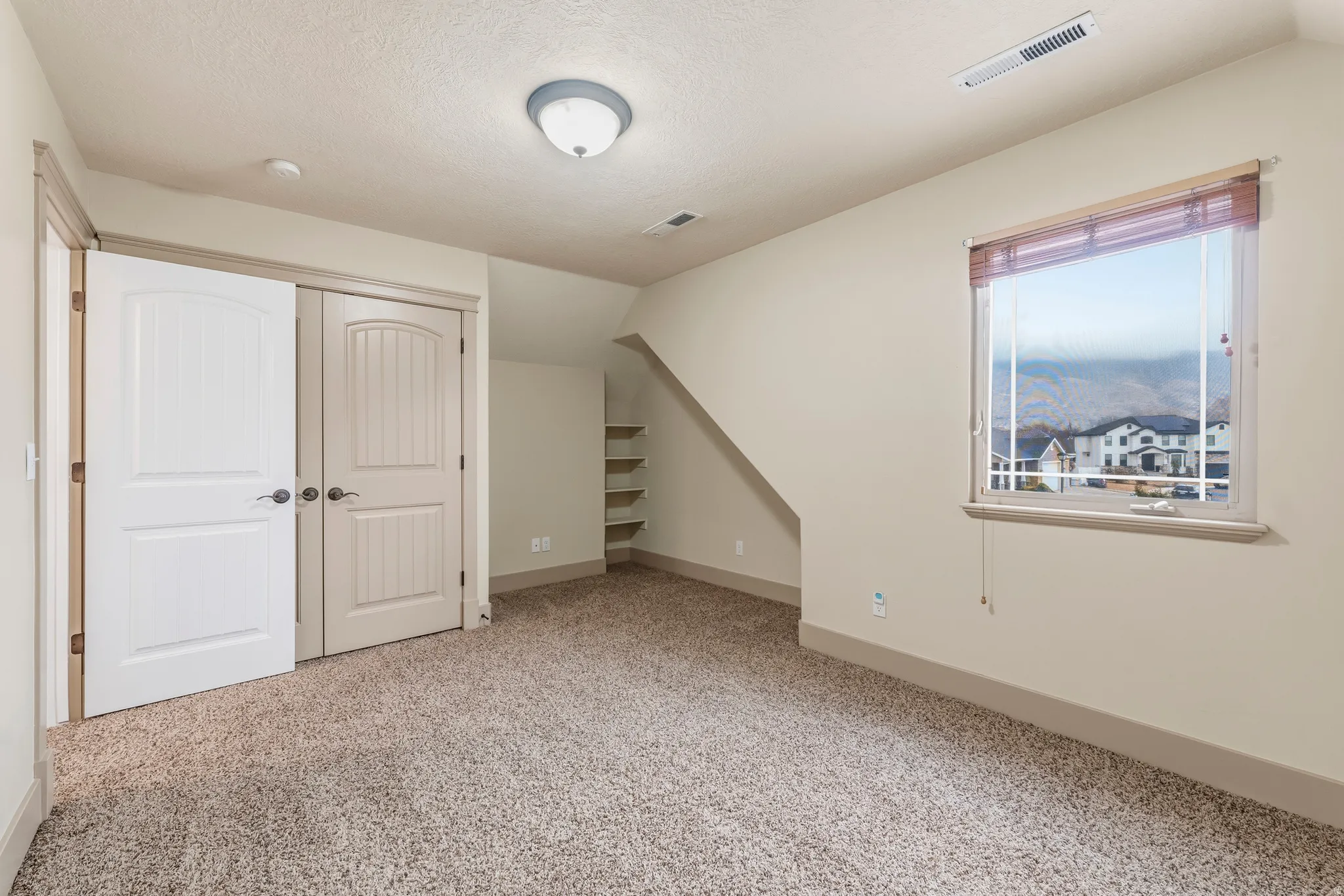 Additional living space featuring vaulted ceiling and light colored carpet