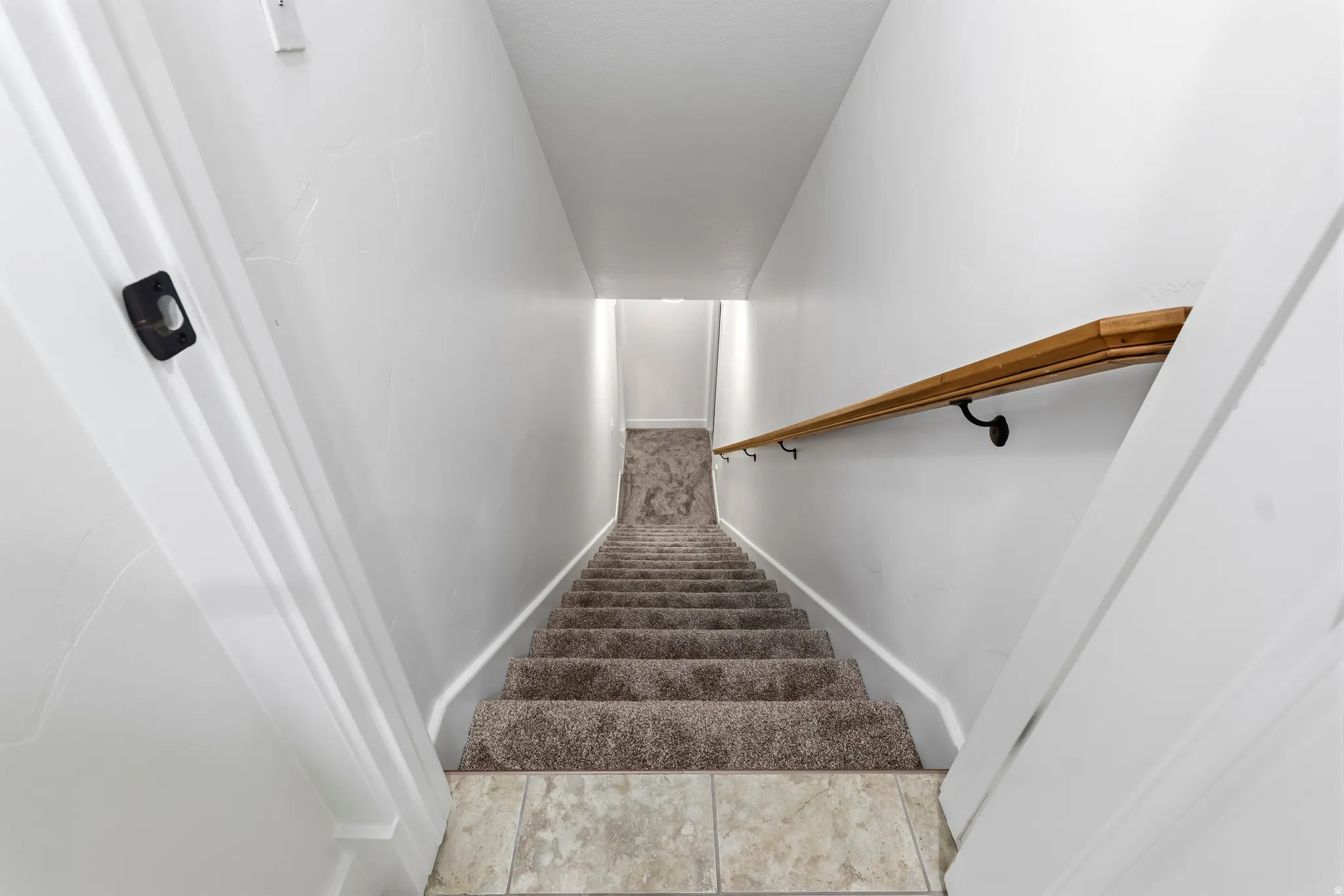 Stairway featuring baseboards and tile patterned flooring