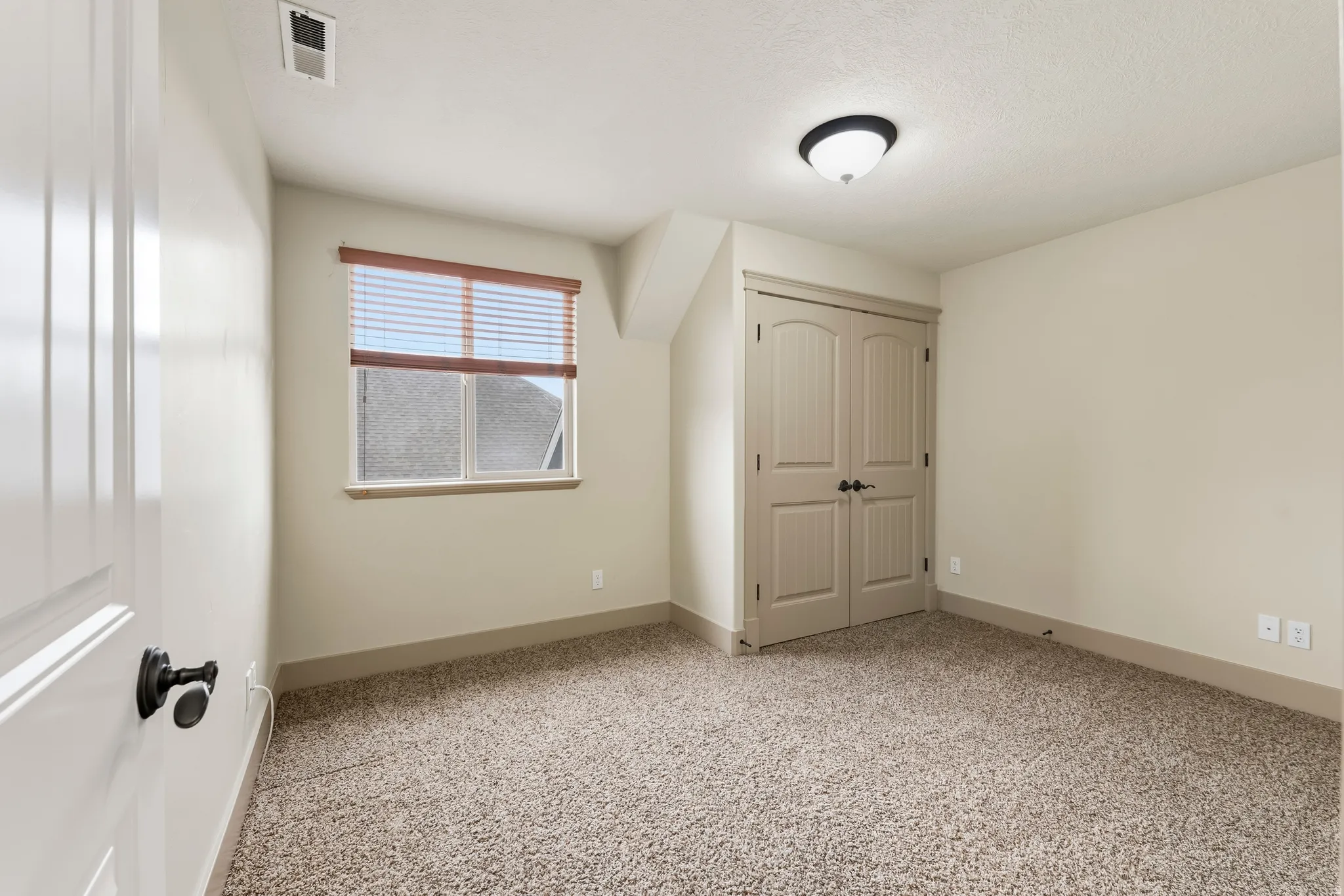 Unfurnished bedroom with light colored carpet and a closet