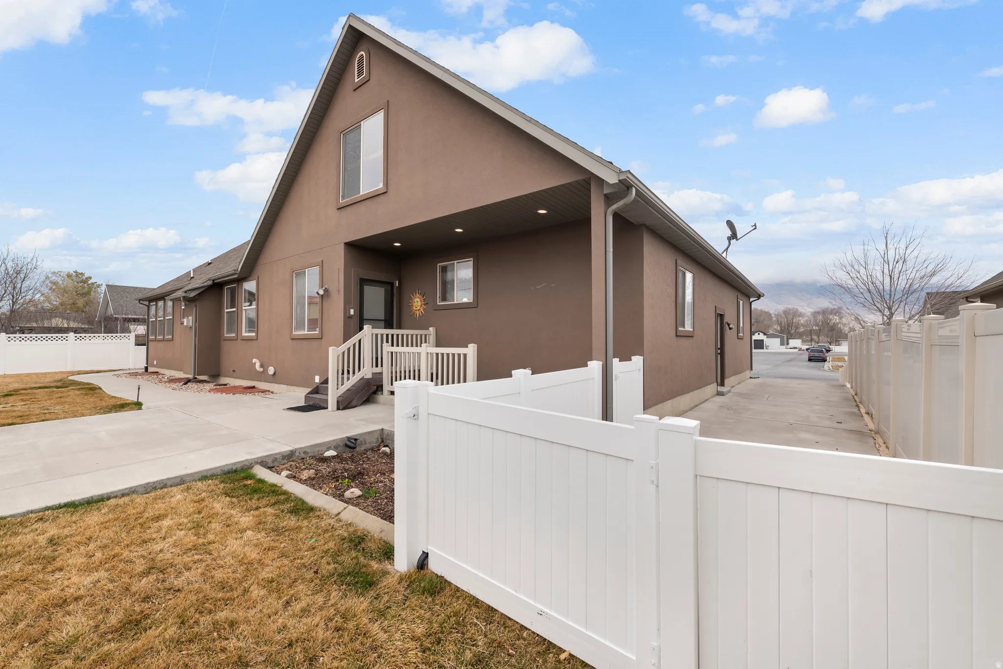 Rear view of property featuring stucco siding and a gate