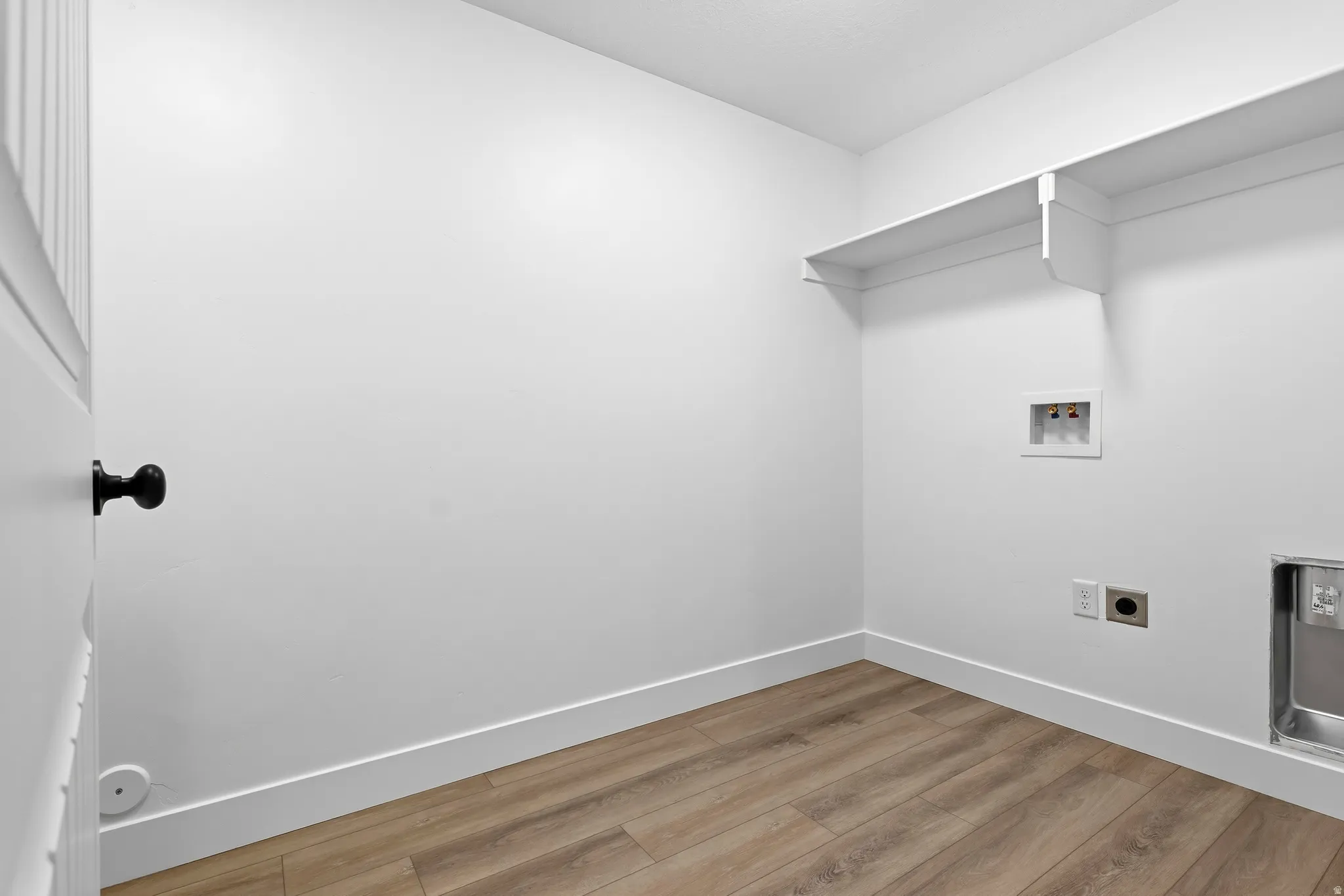 Laundry room featuring light wood finished floors, electric dryer hookup, and washer hookup