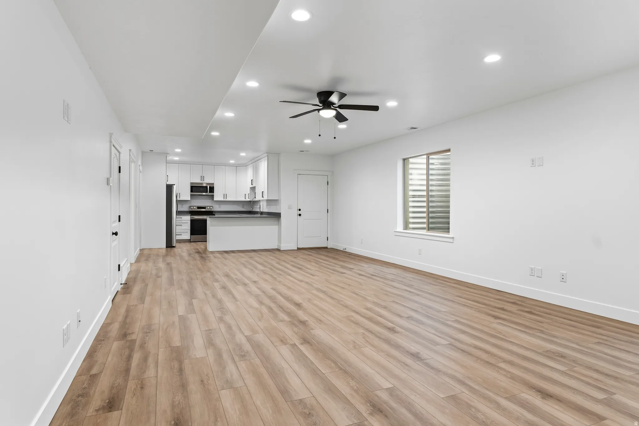 Unfurnished living room featuring recessed lighting, light wood-type flooring, and ceiling fan