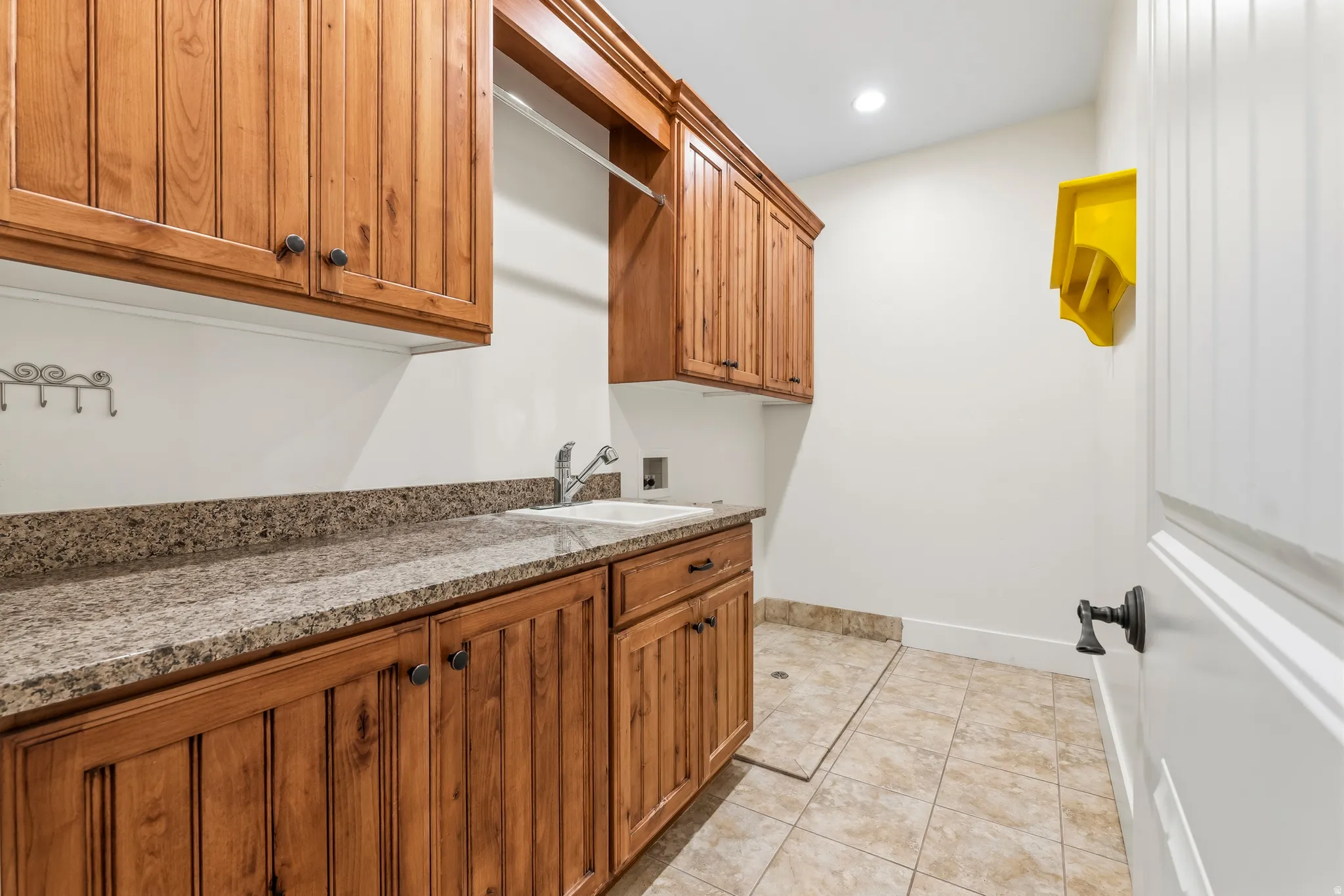 Laundry area featuring hookup for a washing machine, cabinet space, light tile patterned floors, and recessed lighting