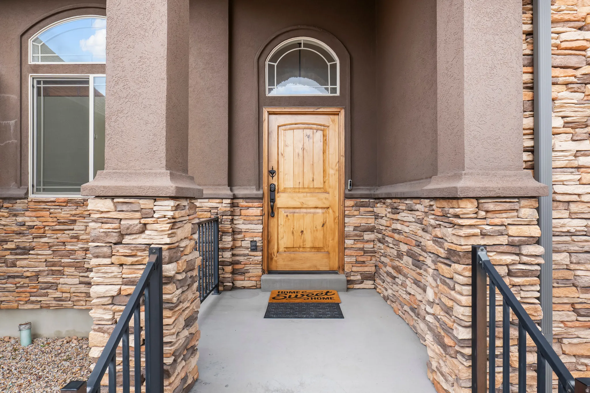 View of exterior entry featuring stone siding and stucco siding