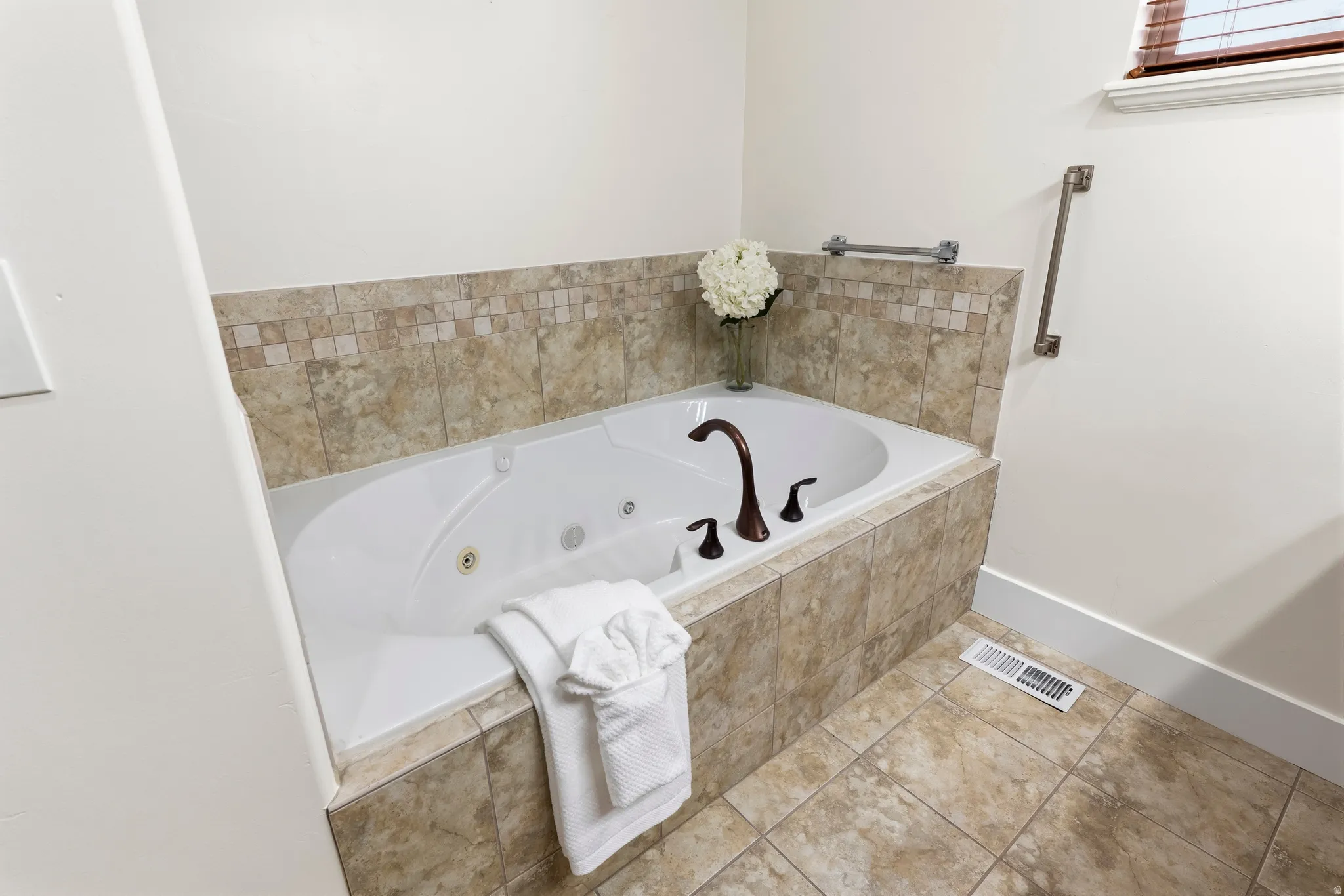 Full bathroom featuring a whirlpool tub and tile patterned floors
