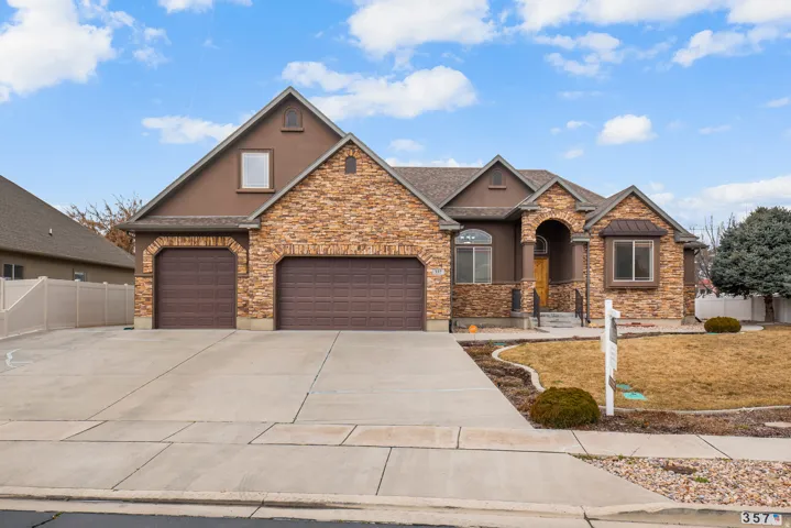 Craftsman house with stucco siding, driveway, and an attached garage