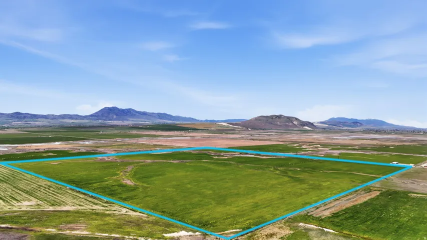 Expansive land parcel featuring open fields and distant mountain scenery