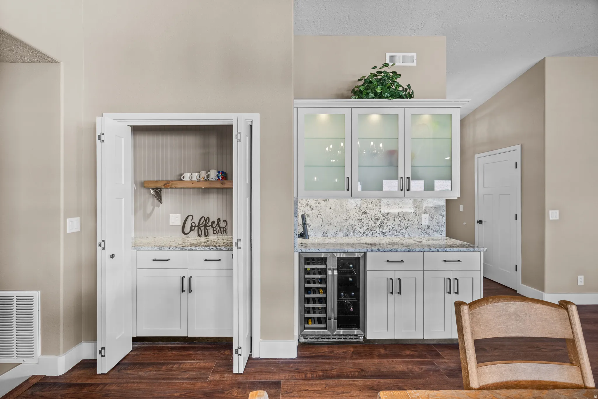 Indoor coffee and wine bar with white cabinetry, granite counters, and beverage cooler