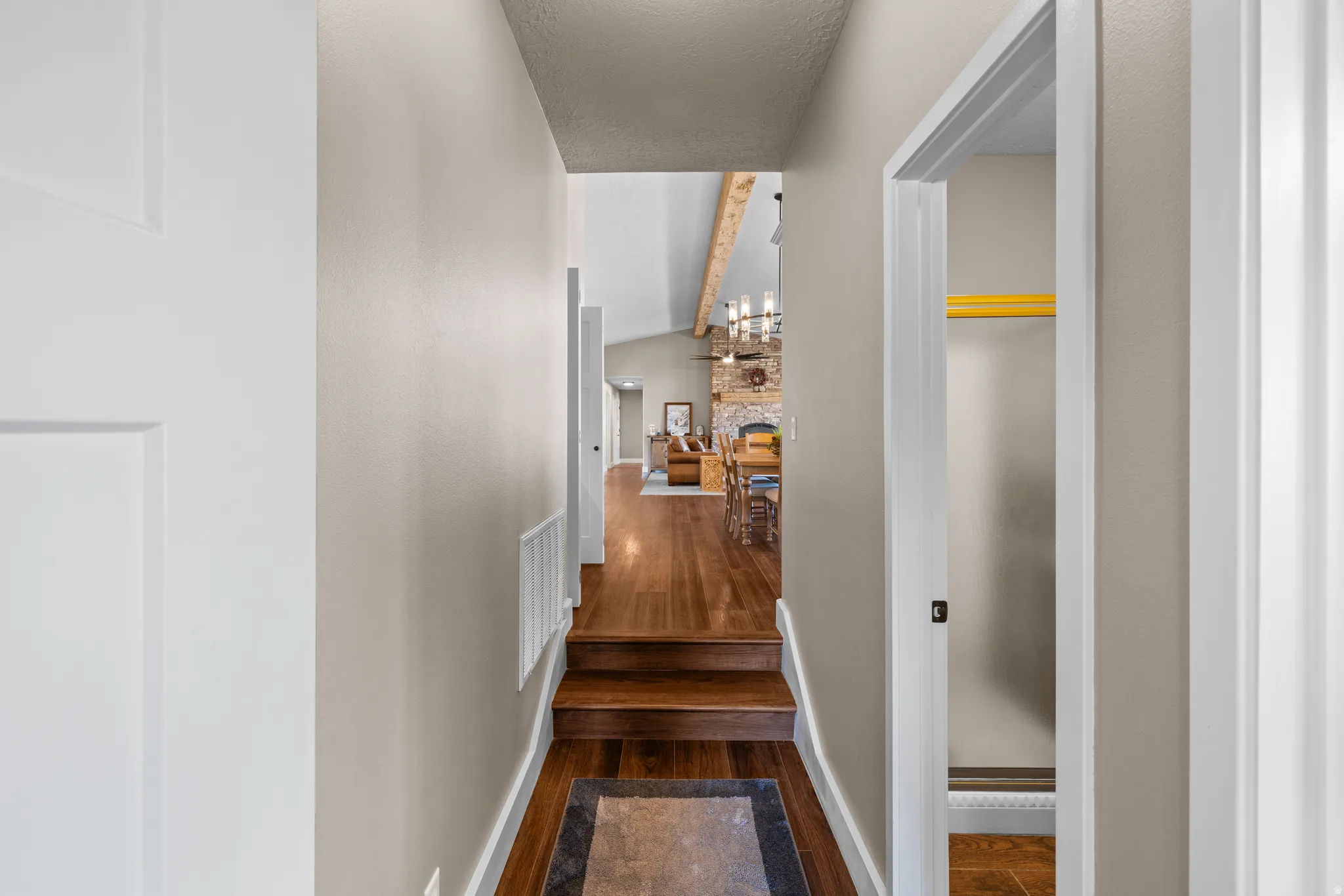 Hall from Grand Room to Den/Flex-space, beam ceiling, and a textured ceiling