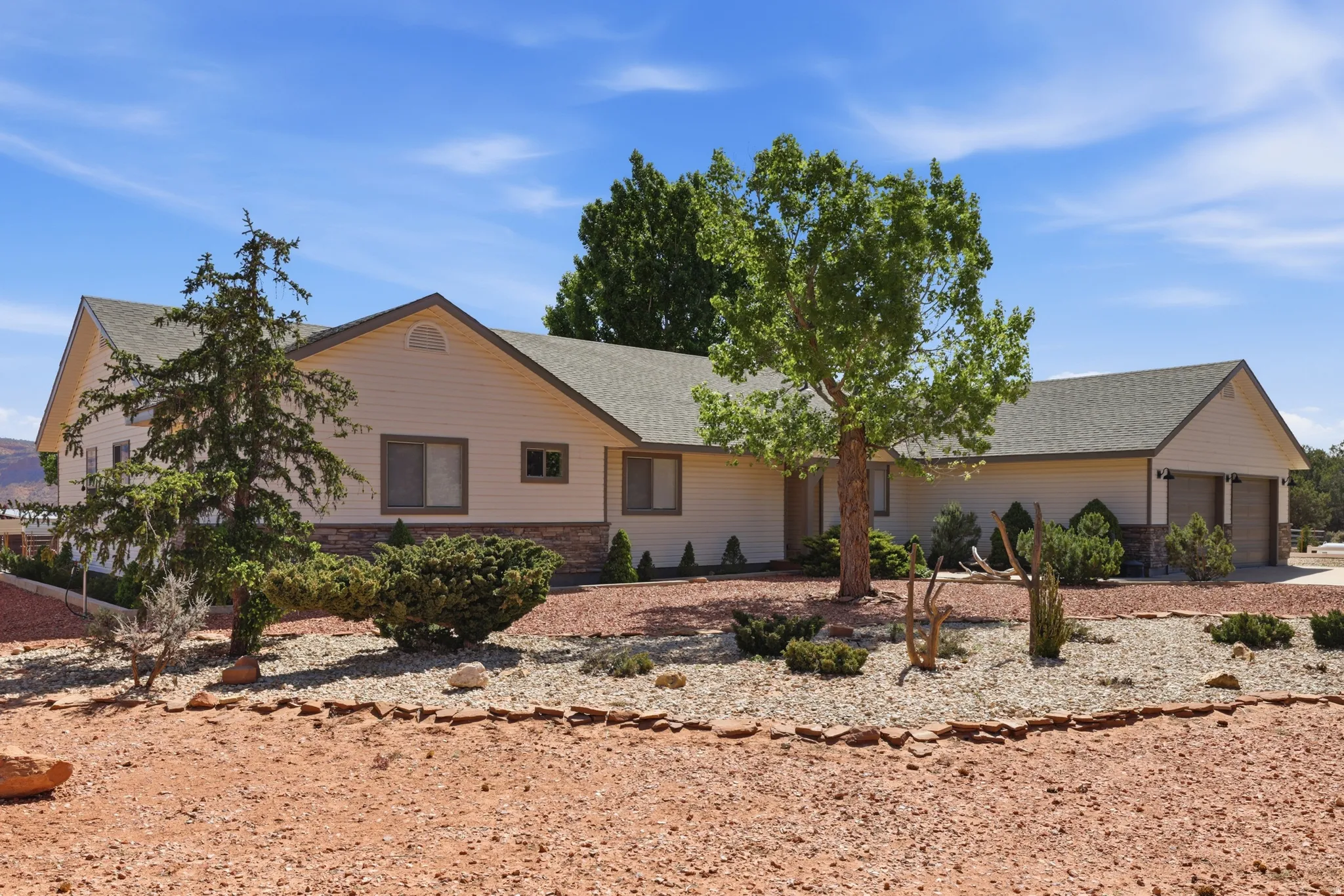 Ranch-style home featuring a shingled roof and an attached garage